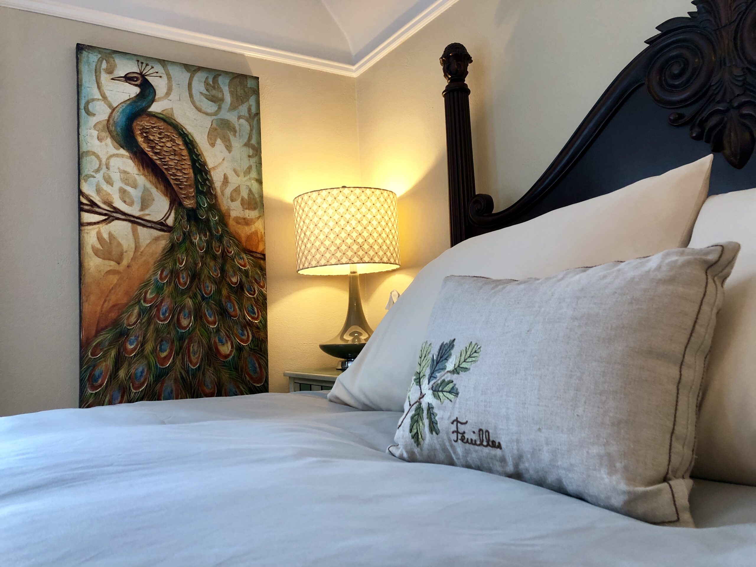 Charles Bed with peacock art on the wall.